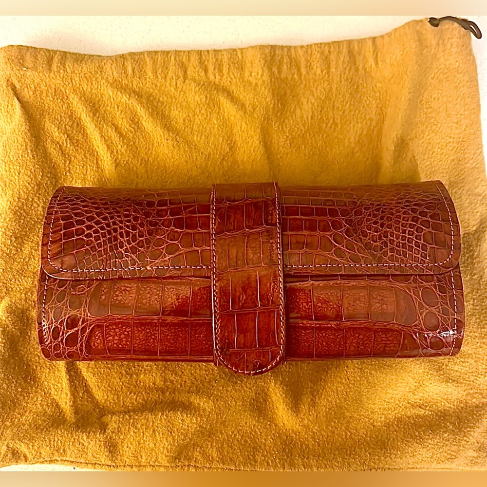 Crocodile print clutch. Suede interior w/zipper. Magnetic snap/strap closure.